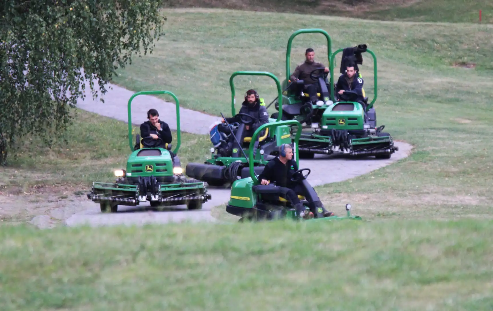 a group of people riding lawnmowers